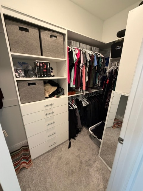 Kids walk-in closet with white cabinetry and drawer tower