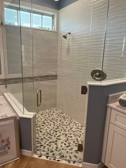 Custom shower with pebble floor and wave tile walls