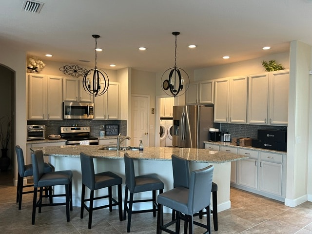 Kitchen remodel with white cabinets, granite island and pendant lighting